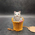 Ceramic cat snuggled in basket