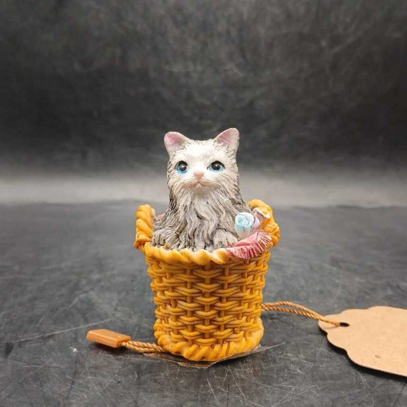 Ceramic cat snuggled in basket