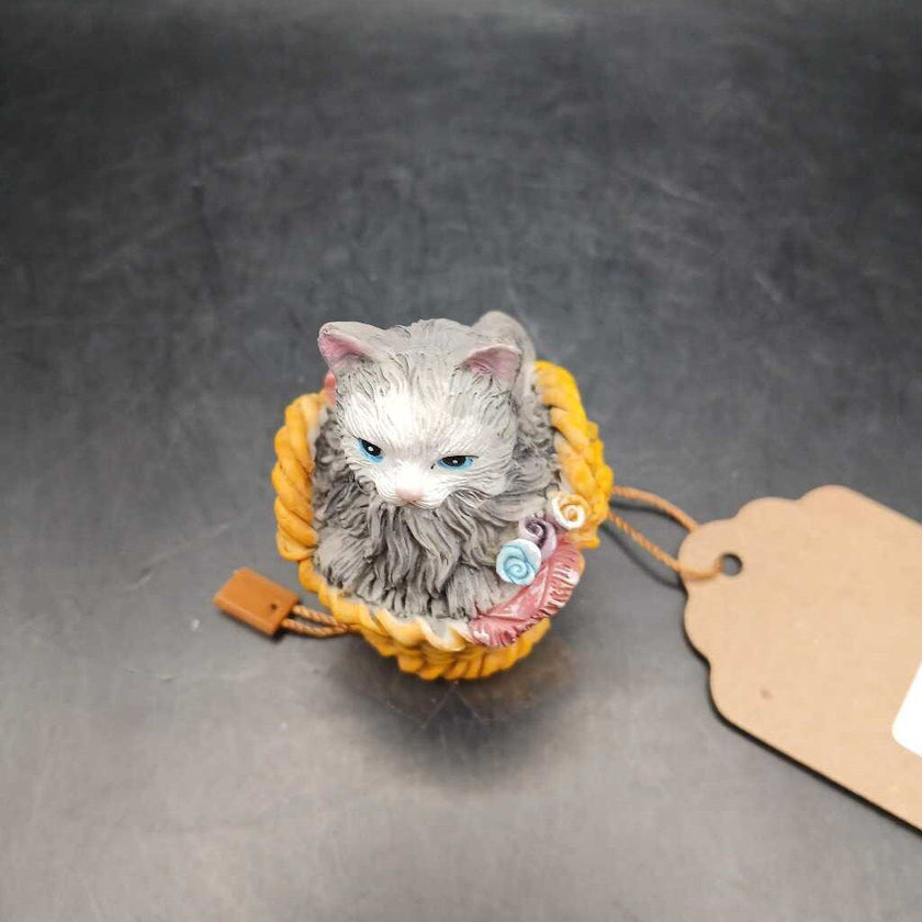 Ceramic cat snuggled in basket