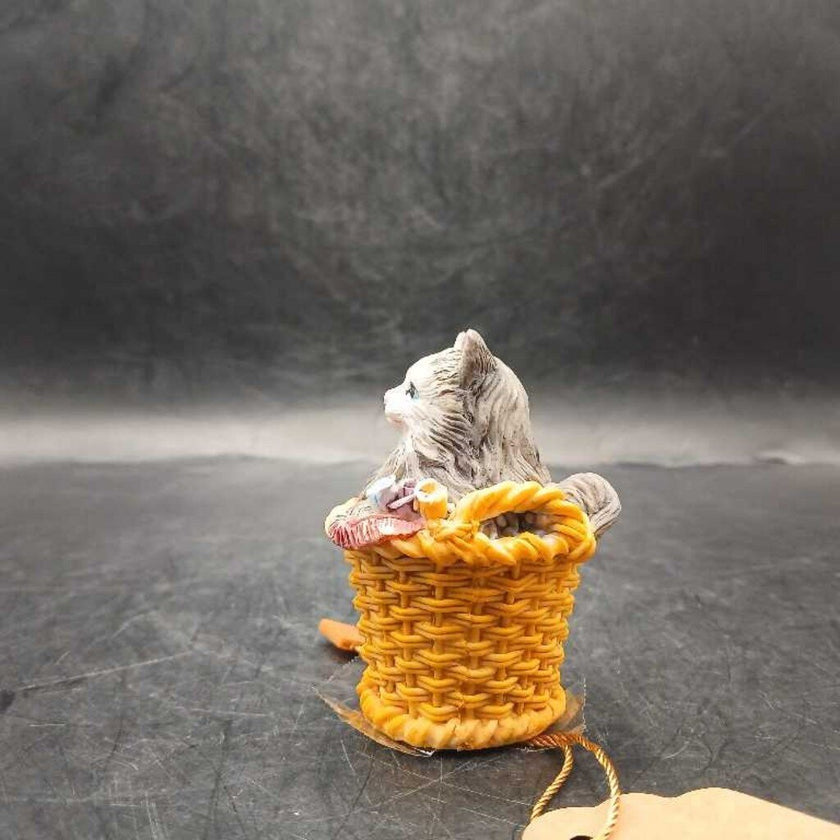 Ceramic cat snuggled in basket
