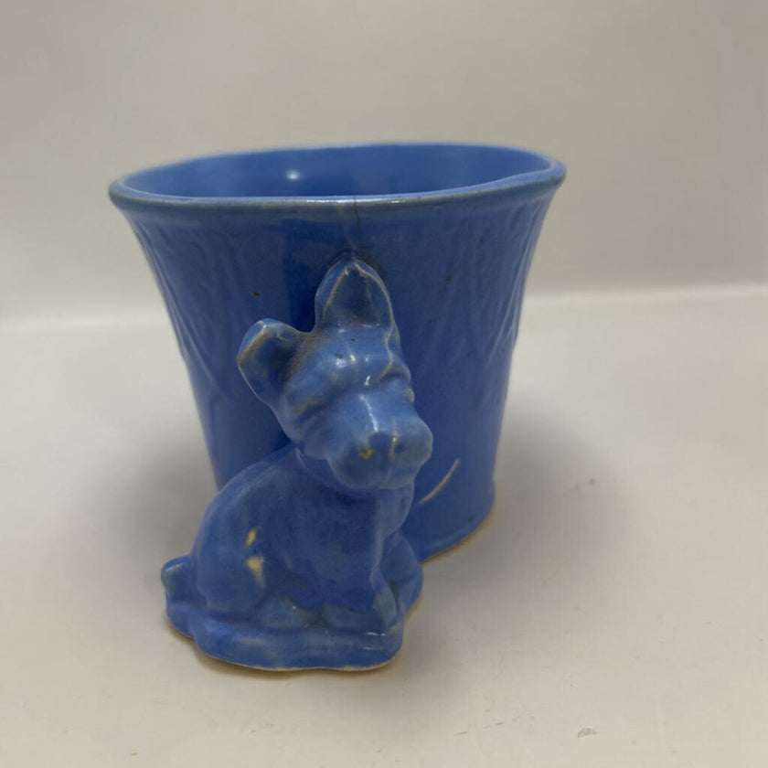 vintage blue ceramic dog planter with artificial flowers.