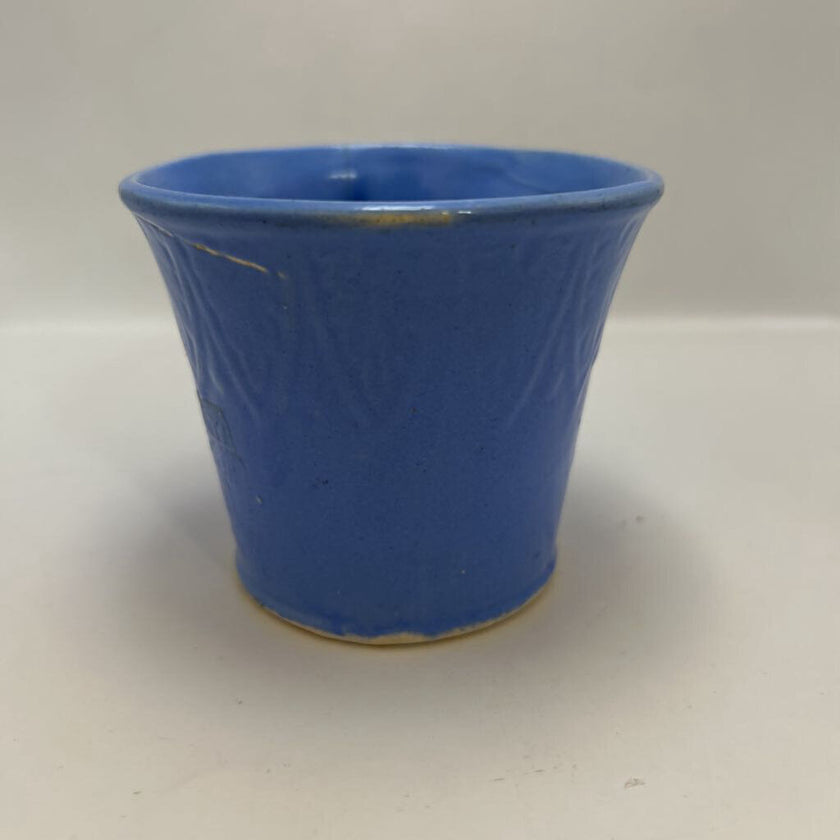 vintage blue ceramic dog planter with artificial flowers.