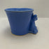 vintage blue ceramic dog planter with artificial flowers.