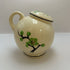 Vintage hand-painted ceramic shaker with green floral design, made in Japan.